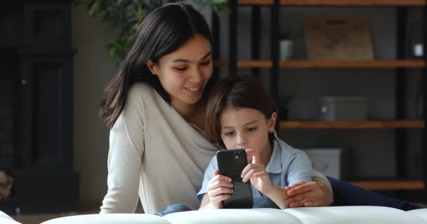 Zorgvuldige babysitter is in de buurt, terwijl kleine jongen met behulp van smartphone gadget — Stockvideo