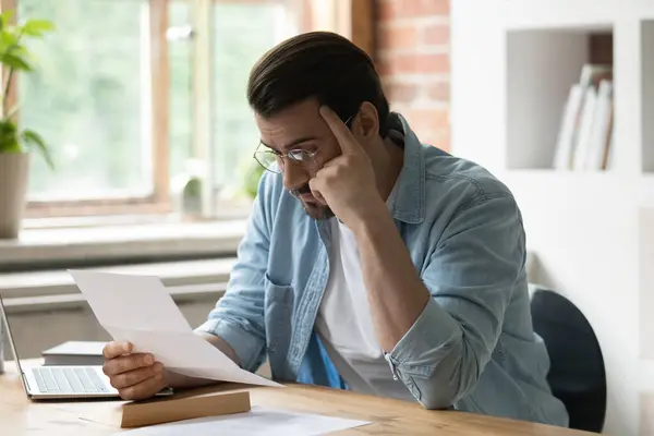 Stressvolle jongeman die papieren brieven leest met slecht nieuws.. — Stockfoto