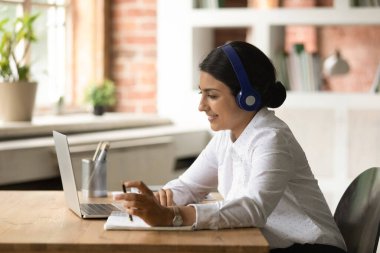 Odaklanmış genç Hintli kadın çevrimiçi kurslara çalışıyor..