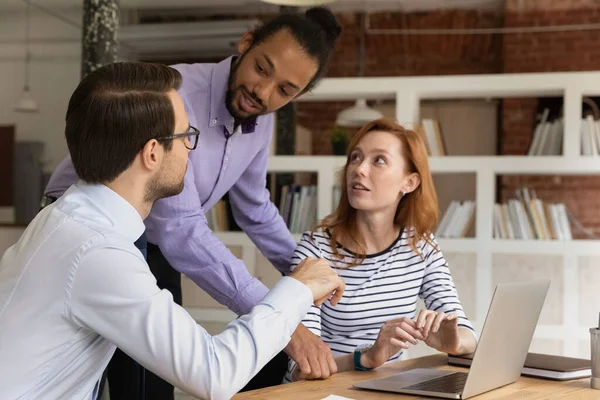 Felices empleados multirraciales haciendo una lluvia de ideas juntos en la oficina moderna. — Foto de Stock