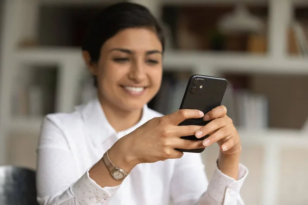 Glad ung indian kvinna som använder smartphone på kontoret. — Stockfoto