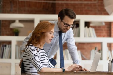 Kendine güvenen erkek takım lideri yeni kadın çalışana yardım ediyor..