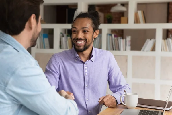 Happy young male team leader shaking hands with african colleague. — Stock Photo, Image