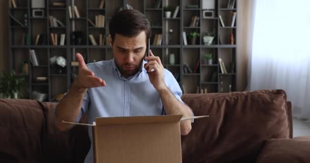 Ο άνθρωπος που κρατά δέμα εκφράζει παράπονα στον πωλητή στο τηλέφωνο — Αρχείο Βίντεο