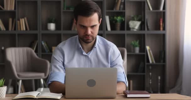 생각있는 진지 한 사람 이 식탁에 앉아 노트북을 만들고 있다 — 비디오