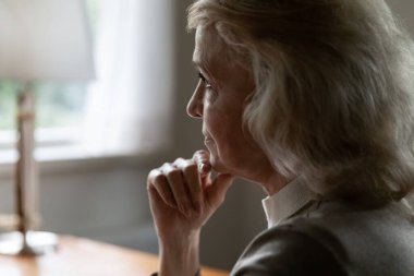 Upset mature female look in distance thinking of maturity