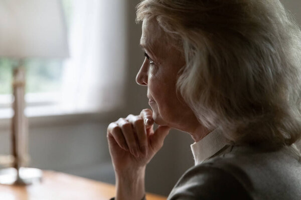 Upset mature female look in distance thinking of maturity