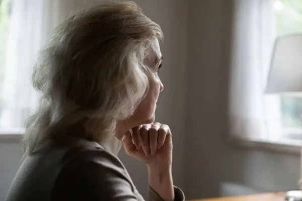 Unhappy old female look in distance feeling lonely — Stock Photo, Image