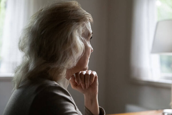 Unhappy old female look in distance feeling lonely