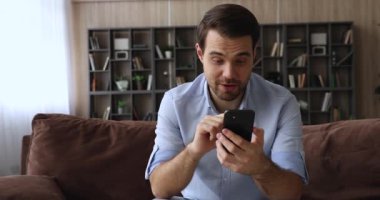 Cep telefonunda SMS okuyan adam başarıyı kutlarken mutlu olur.