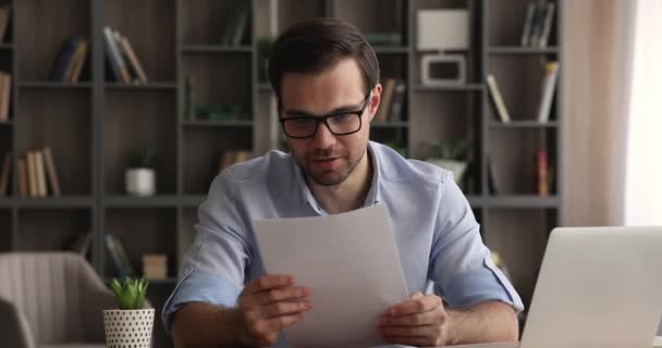 Excité jeune gars heureux de lire de bonnes nouvelles dans le document — Video