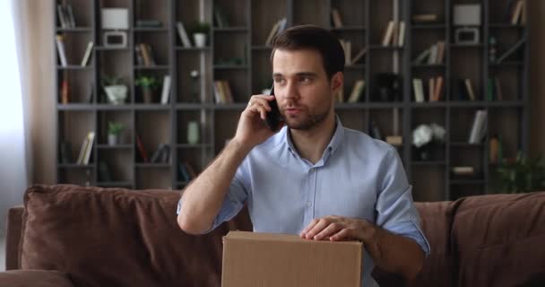 Homem segurando encomendas fala no smartphone para mensageiro — Vídeo de Stock