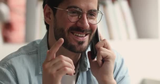 Boldog fiatal fehér férfi szemüvegben beszél mobilon. — Stock videók