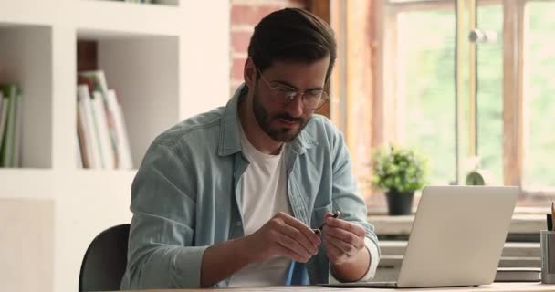 Joven hombre de negocios concentrado en gafas trabajando en el proyecto en línea. — Vídeos de Stock