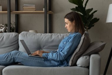 Happy young freelance woman working on computer at home.