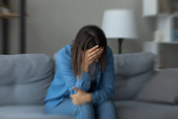 Estressado infeliz jovem mulher sentada no sofá. — Fotografia de Stock