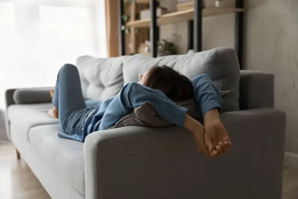 Relaxed millennial woman lying on comfortable sofa. — Stok fotoğraf