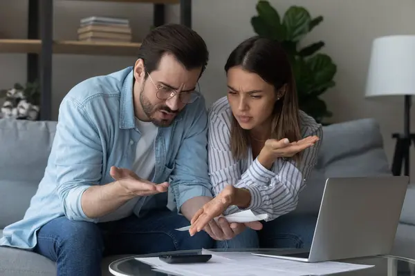 Anxious young family couple calculating domestic expenses.