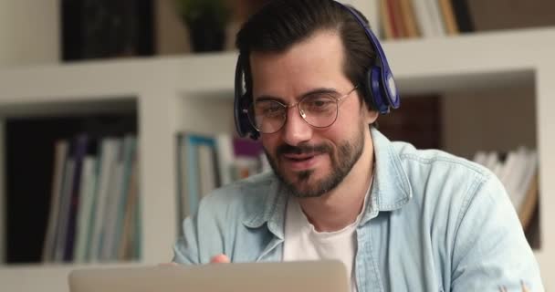 Šťastný mladý muž těší vzdálenou komunikaci pomocí počítačové aplikace. — Stock video