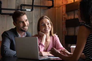 Happy excited young family couple meeting real estate agent.