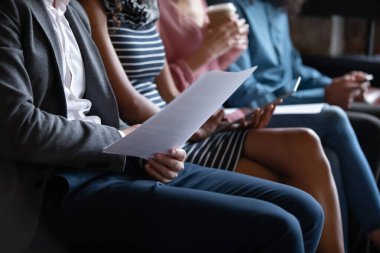 Closeup unrecognizable young multiracial people sitting in line on sofa.