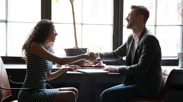 Happy young african woman shaking hands with man. — Stock Photo, Image