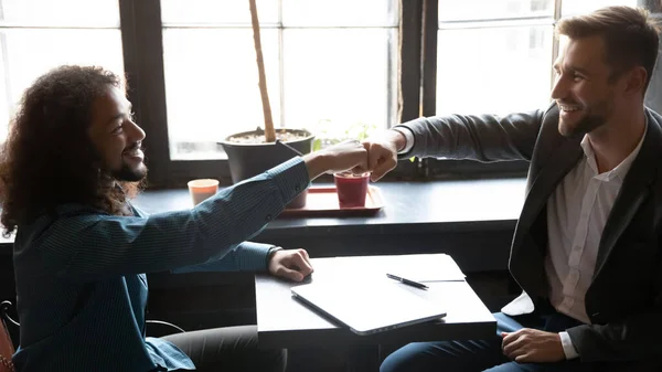 Sincere african american man bumping fists with caucasian friend. — Stock Photo, Image