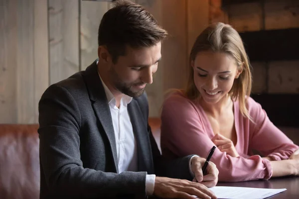Happy young family couple signing agreement at meeting. — Stock Photo, Image