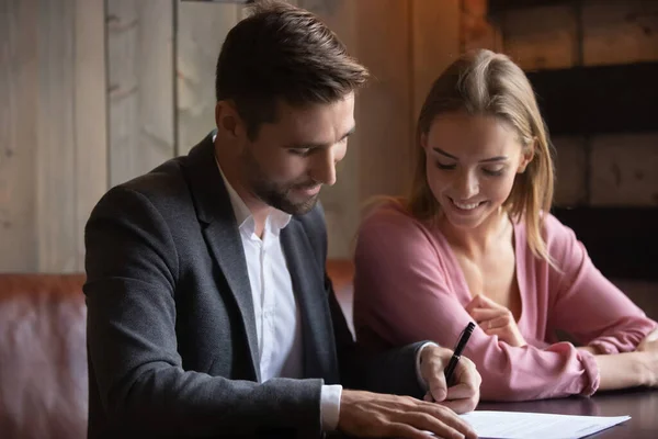 Happy young family couple signing agreement at meeting. — Stok fotoğraf