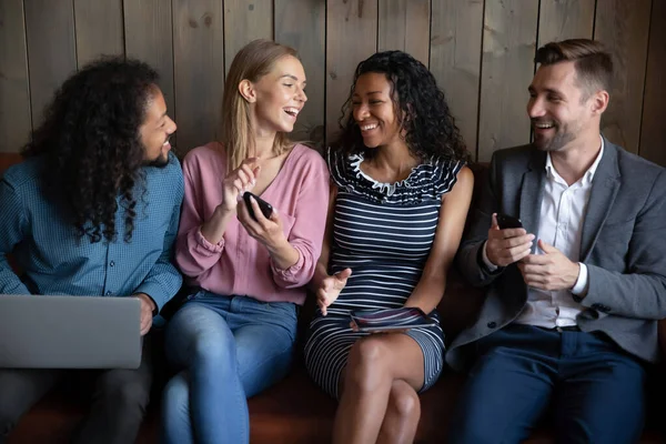 Happy young mixed race friendly people using different gadgets. — Stock Photo, Image