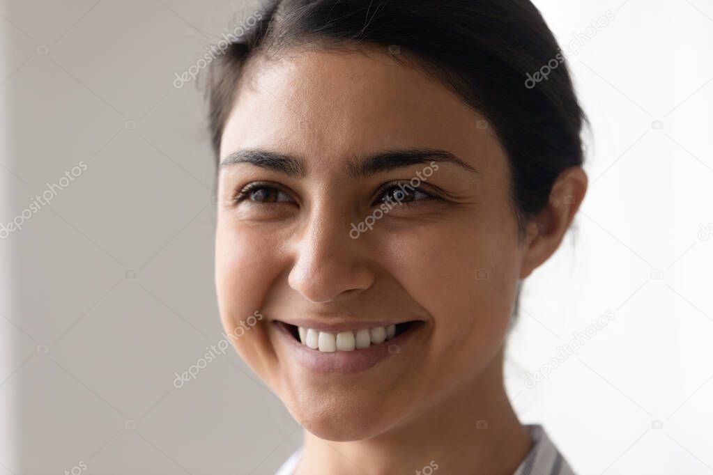 Smiling Indian woman look in distance making plans