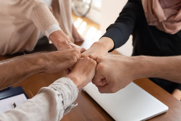 Close up motivated diverse employees joining fists at corporate meeting — Stock Photo, Image