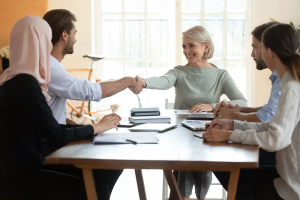 Glimlachende middelbare leeftijd executive schudden zakenman hand op corporate meeting — Stockfoto