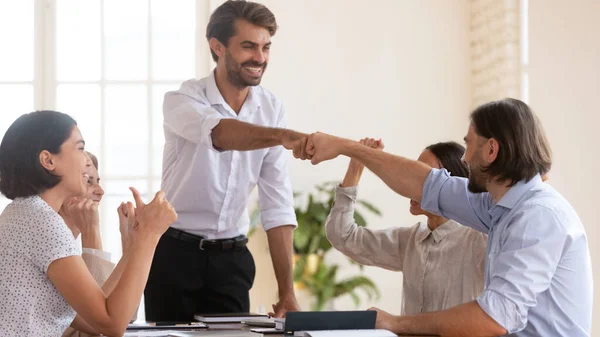 Sonrientes puños ejecutivos chocando con el empleado en la reunión corporativa —  Fotos de Stock