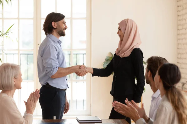 Ejecutivo sacudiendo la mano musulmana asiática empresaria en reunión corporativa — Foto de Stock