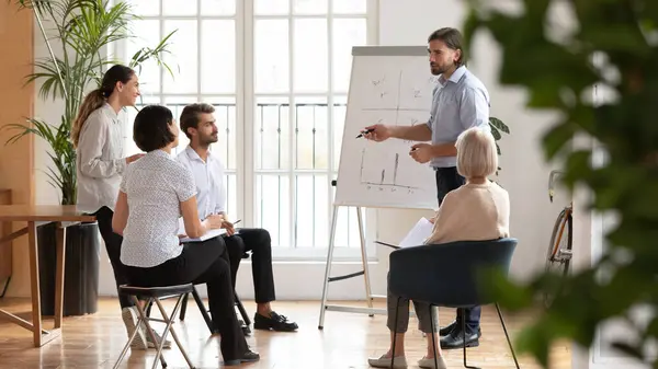 Zelfverzekerde zakenman coach maakt flip-over presentatie op workshop — Stockfoto