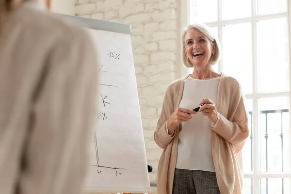 Opgewonden middelbare leeftijd zakenvrouw coach maken flip-over presentatie — Stockfoto