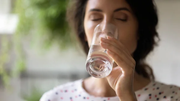 Cerca hermosa mujer bebiendo agua mineral fresca, sosteniendo el vidrio — Foto de Stock