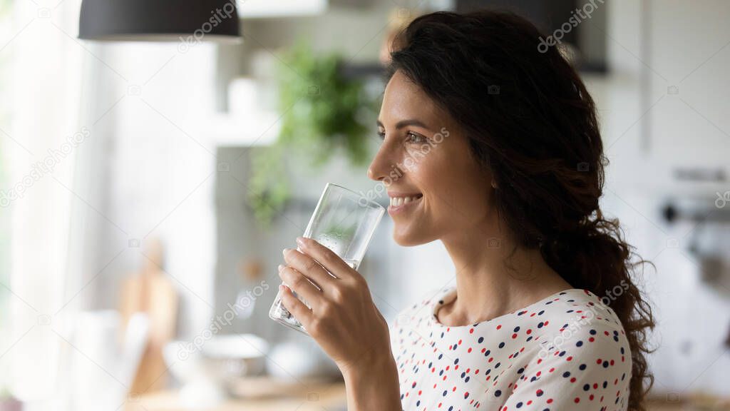 Close up profile of smiling woman holding glass of water