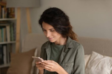 Yakın çekim çekici kadın akıllı telefon tutuyor, ekrana bakıyor.