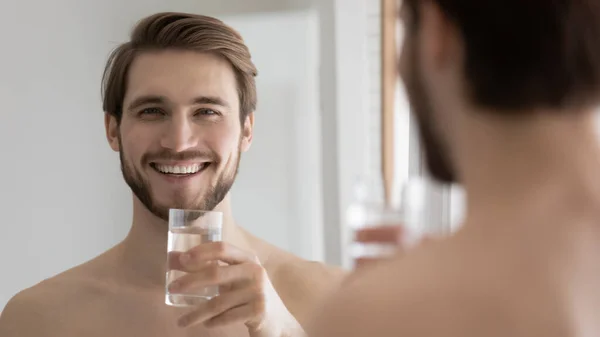 Happy attractive millennial guy drinking good pure fresh water — Stock Photo, Image