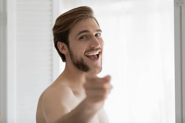 Excited handsome shirtless millennial guy pointing finger — Stock Photo, Image