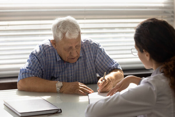 Зрелый мужчина подписывает бумаги в больнице
