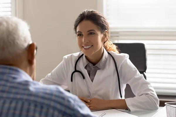 Un médecin souriant consulte un patient masculin âgé à la clinique — Photo