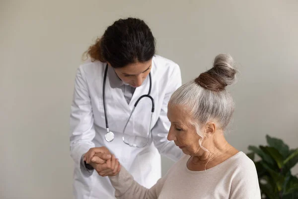 Enfermera cuidadora ayuda paciente anciana — Foto de Stock