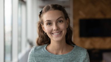 20 'li yaşlarda gülümseyen genç bir kadının portresi..