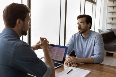 Yetenekli genç erkek insan kaynakları müdürü adayla iş görüşmesi yapıyor..