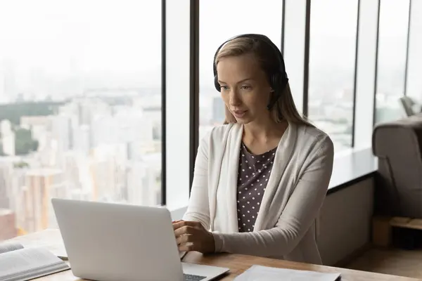 Concentrado joven rubia mujer de negocios celebración de videollamada. — Foto de Stock