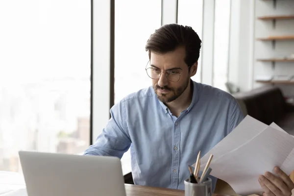 Kluger junger Geschäftsmann aus den 30er Jahren analysiert Dokumente. — Stockfoto