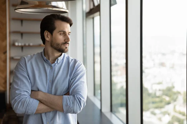 Confident pensive young man looking out of window. — Stock Photo, Image